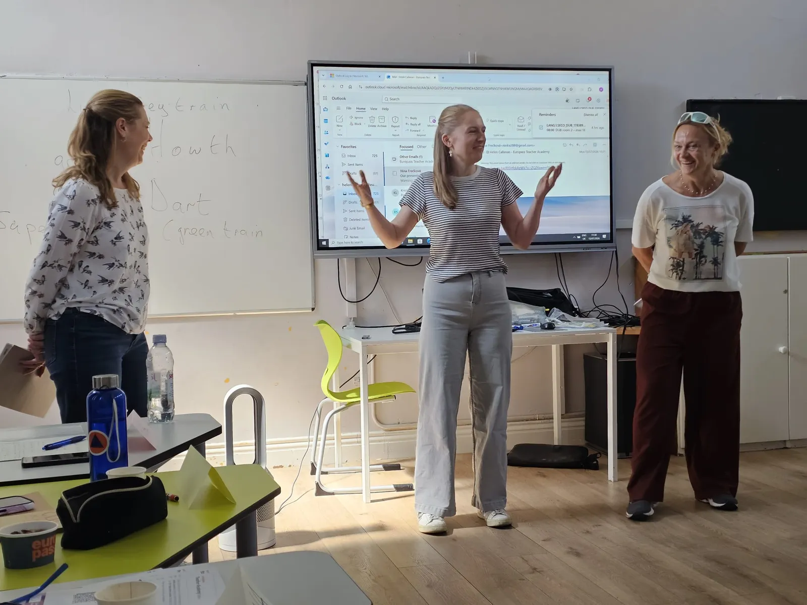 Drei Lehrerinnen präsentieren vor einer interaktiven Tafel im Kursraum