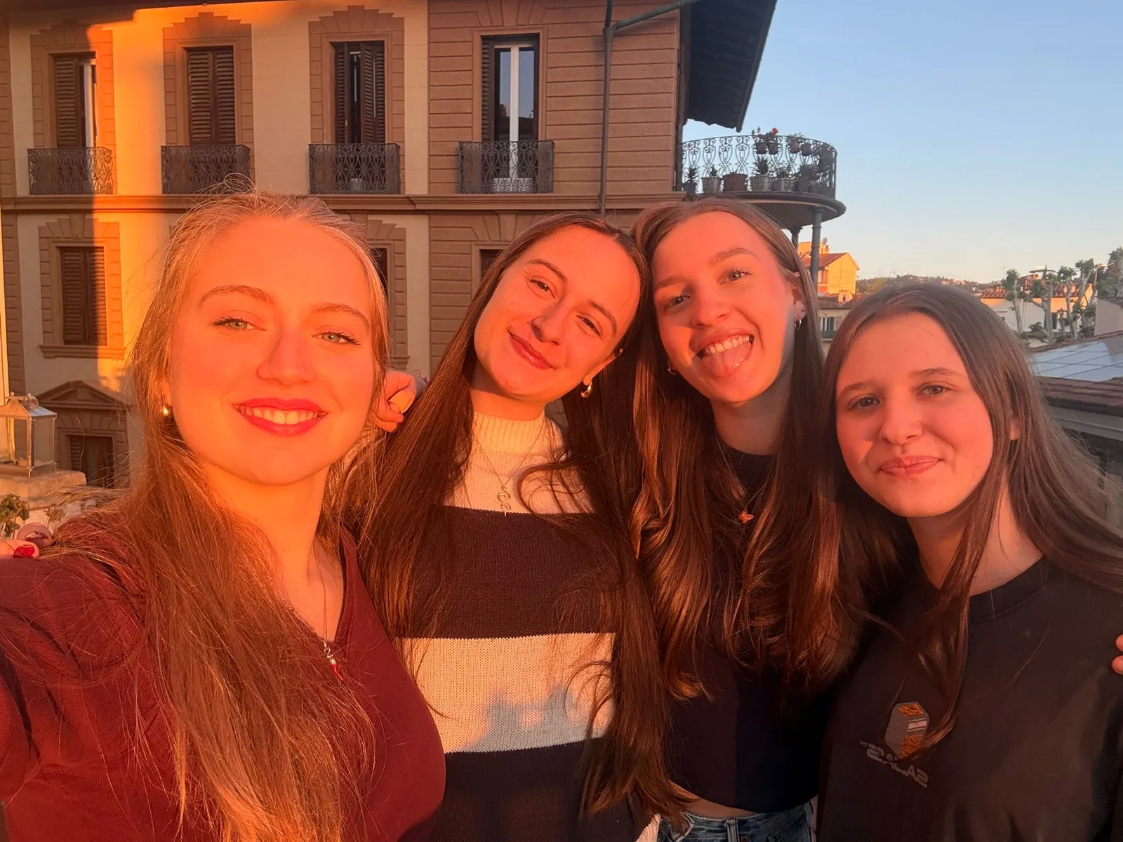 Vier Schülerinnen beim Selfie auf einer Dachterrasse in der Abendsonne
